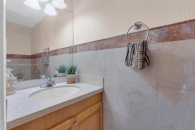 bathroom featuring vanity and tile walls