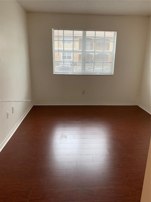 spare room with dark hardwood / wood-style flooring