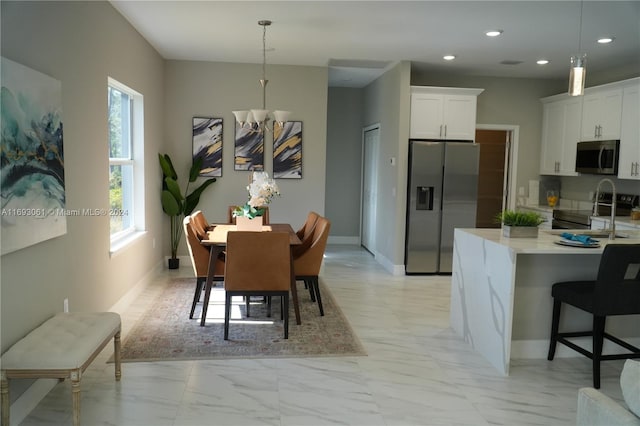 dining area with sink and a notable chandelier