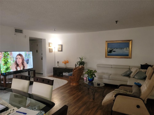 living room featuring wood-type flooring and a textured ceiling