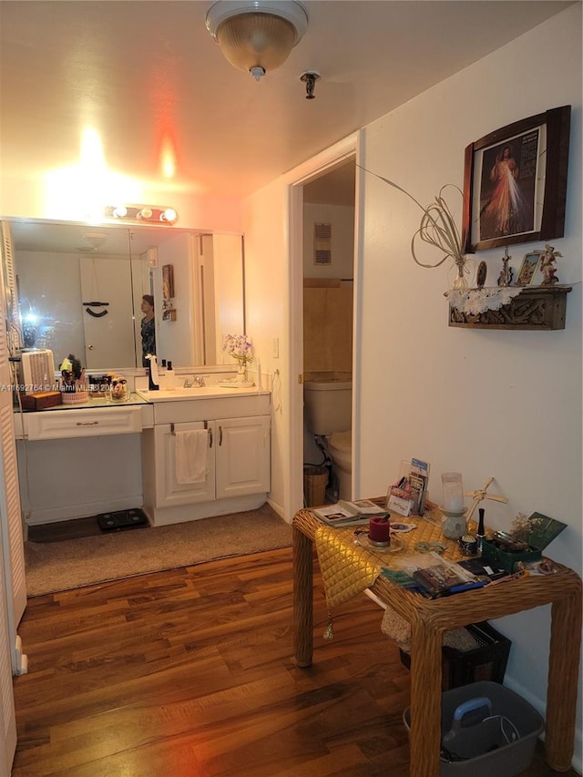 bathroom featuring wood-type flooring, toilet, and vanity