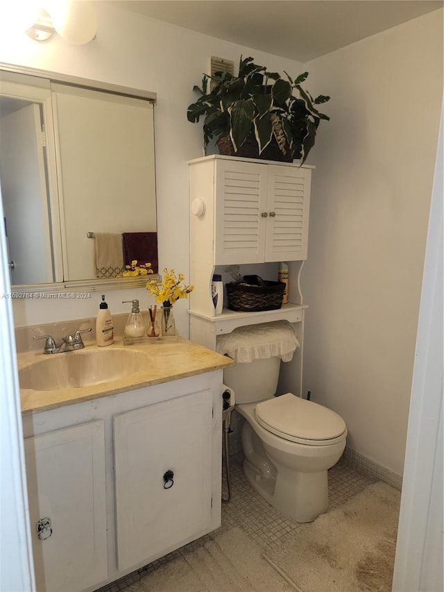 bathroom featuring vanity, tile patterned floors, and toilet