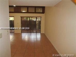 unfurnished room featuring dark tile patterned floors