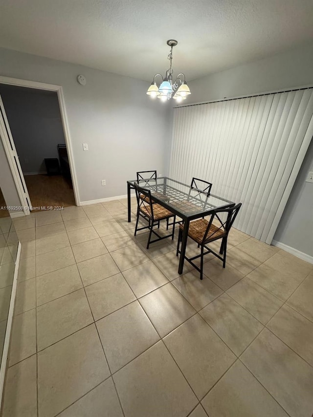 tiled dining room featuring a chandelier