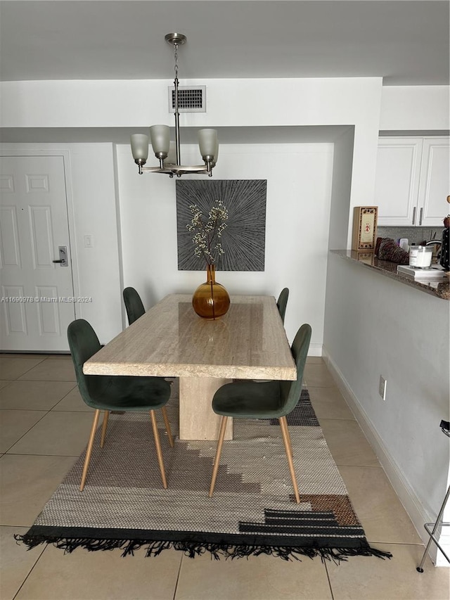 dining room with light tile patterned floors and a chandelier