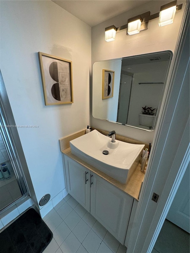 bathroom featuring walk in shower, tile patterned flooring, vanity, and toilet