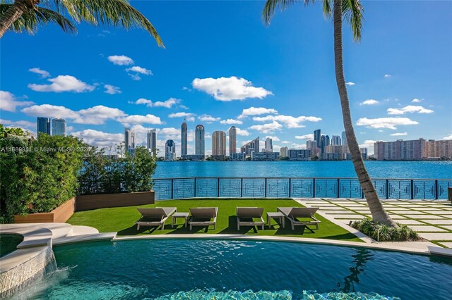 view of pool with a lawn and pool water feature