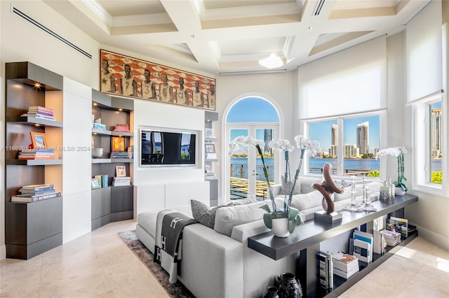 living room featuring beam ceiling, a high ceiling, coffered ceiling, tile patterned floors, and crown molding