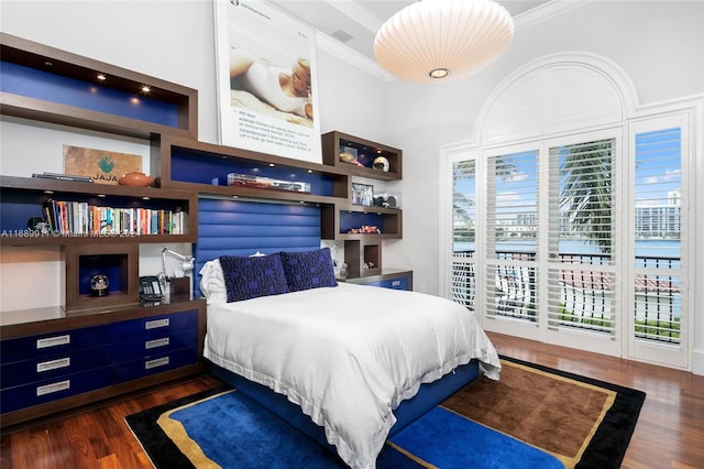 bedroom with access to exterior, dark hardwood / wood-style flooring, and ornamental molding