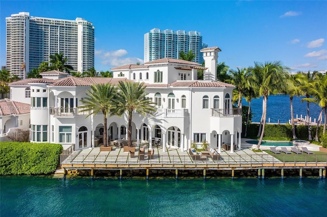 rear view of property with a balcony and a water view