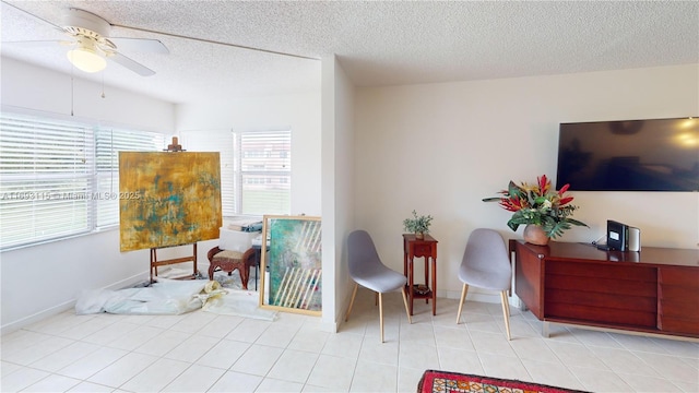 living area with light tile patterned floors, a textured ceiling, and ceiling fan