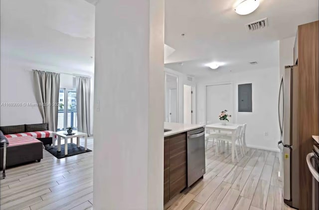 kitchen with appliances with stainless steel finishes and light hardwood / wood-style floors