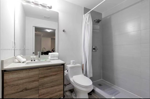 bathroom with a shower with shower curtain, vanity, and toilet