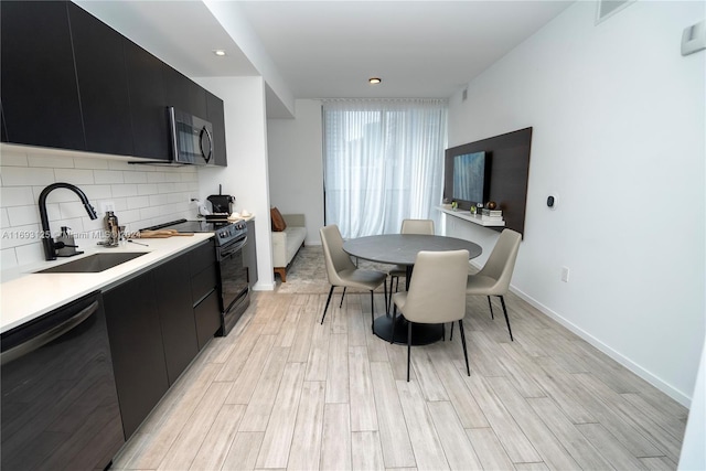 398 NE 5th St Unit 1617, Miami, FL 33132 - kitchen featuring dark cabinetry, appliances with stainless steel finishes, a sink, modern cabinets, and recessed lighting