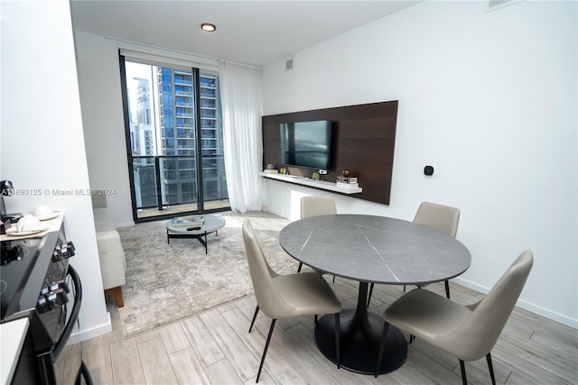 dining room featuring expansive windows and light hardwood / wood-style flooring