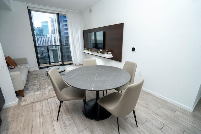 dining room featuring expansive windows and light hardwood / wood-style flooring