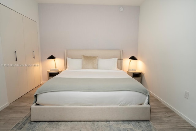 bedroom with wood-type flooring and a closet