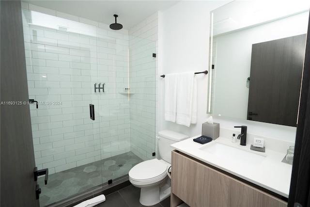 bathroom featuring vanity, a shower with door, tile patterned flooring, and toilet