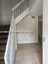 staircase featuring tile patterned flooring