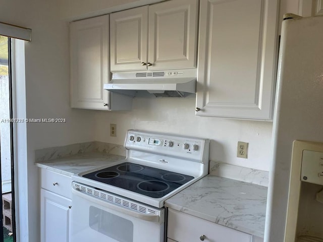 kitchen with white cabinetry, light stone counters, and white appliances