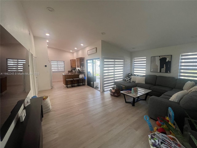 living room with light hardwood / wood-style floors and lofted ceiling