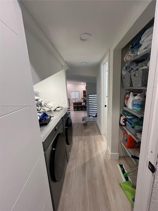 clothes washing area featuring washer and dryer and light hardwood / wood-style floors