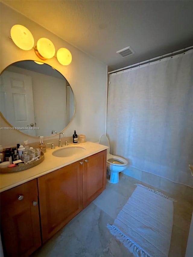 bathroom featuring curtained shower, vanity, and toilet