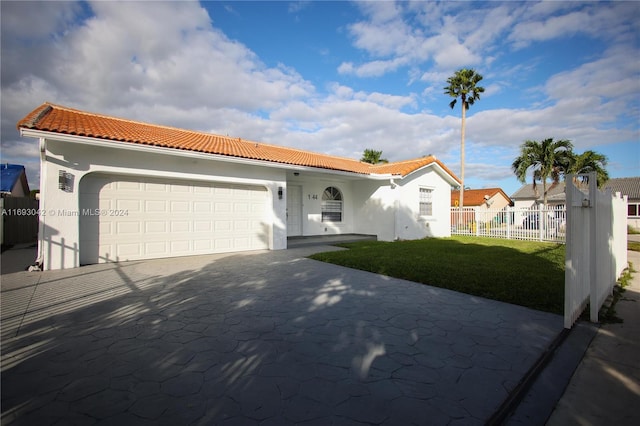 mediterranean / spanish-style home featuring a front yard and a garage