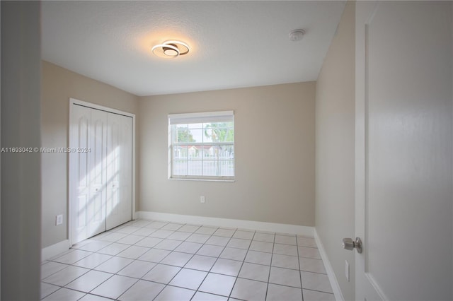 spare room featuring light tile patterned floors and a textured ceiling