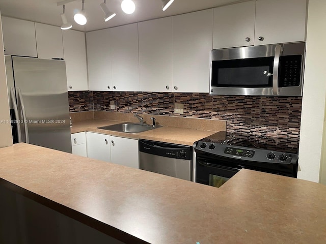 kitchen with white cabinets, decorative backsplash, appliances with stainless steel finishes, and sink