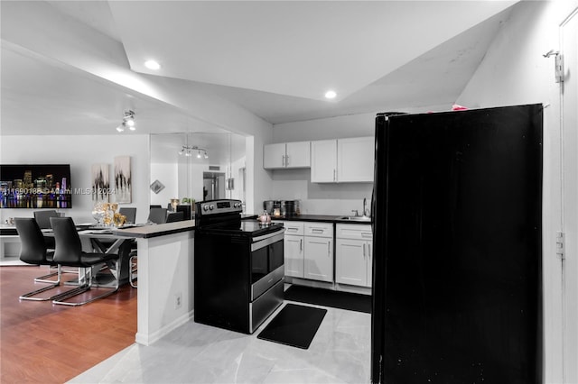 kitchen with black fridge, sink, electric range oven, white cabinets, and light wood-type flooring