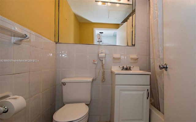 bathroom featuring vanity, toilet, and tile walls