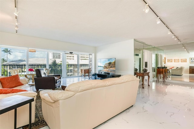 living room featuring rail lighting and a textured ceiling