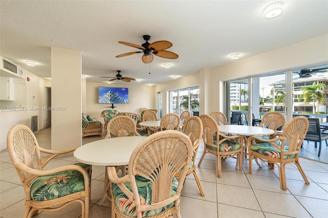 dining space with a textured ceiling, light tile patterned floors, and ceiling fan