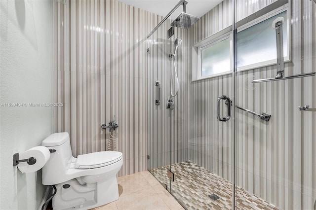 bathroom featuring tile patterned floors, toilet, and a shower with shower door