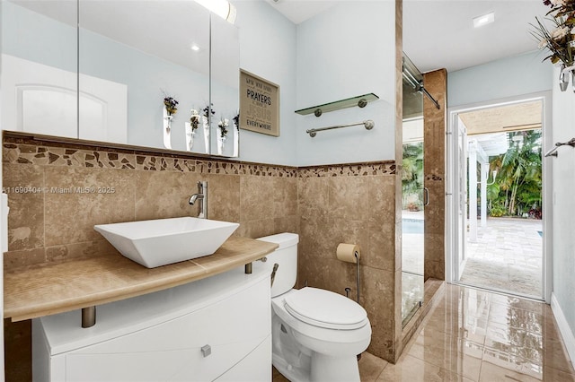 bathroom featuring vanity, toilet, and tile walls