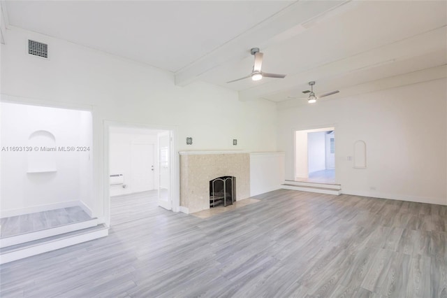 unfurnished living room featuring ceiling fan, beamed ceiling, and light wood-type flooring