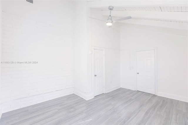 unfurnished room featuring light hardwood / wood-style floors, beamed ceiling, and high vaulted ceiling