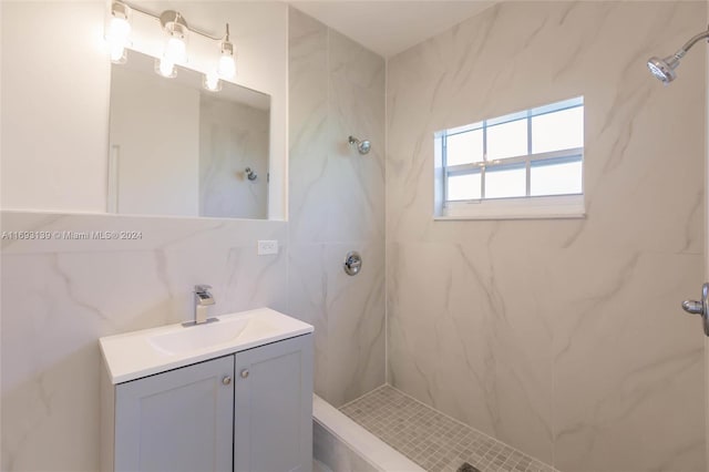 bathroom featuring vanity, tile walls, a tile shower, and tasteful backsplash