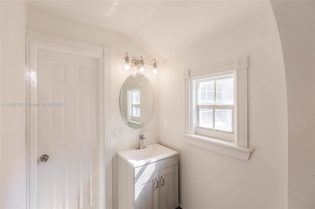 bathroom with lofted ceiling and vanity