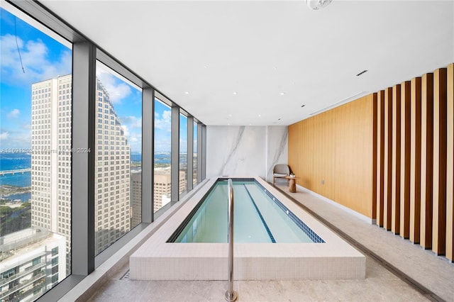 view of pool with a hot tub and a water view