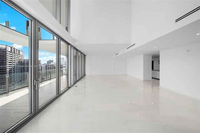 tiled empty room featuring a towering ceiling