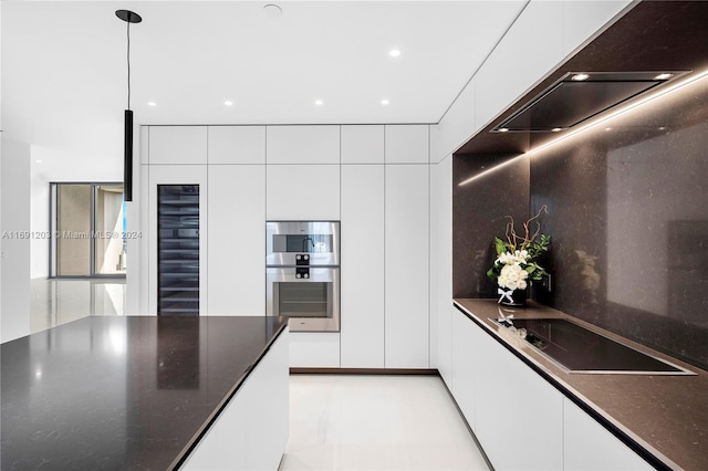 kitchen featuring stovetop, white cabinets, beverage cooler, and decorative light fixtures