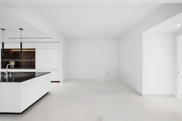 kitchen with white cabinets, sink, and pendant lighting