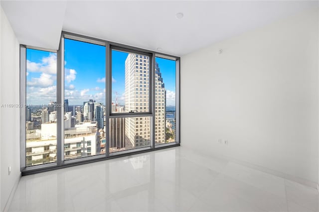 empty room featuring floor to ceiling windows and tile patterned floors