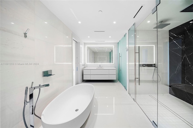 bathroom with vanity, tile patterned floors, separate shower and tub, and tile walls