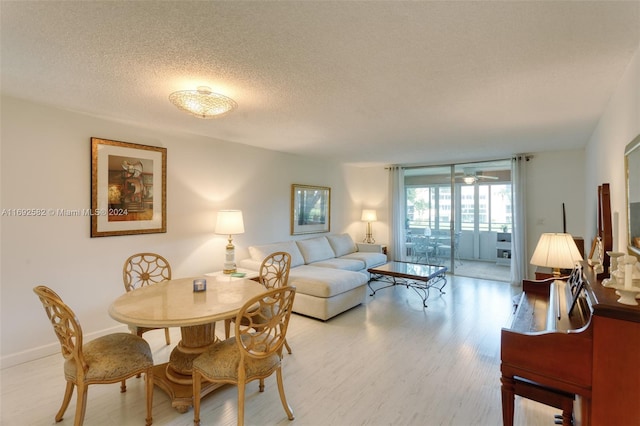 dining area featuring light hardwood / wood-style flooring, a textured ceiling, and ceiling fan