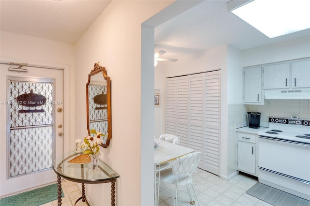 kitchen featuring tasteful backsplash, electric stove, a textured ceiling, and ceiling fan