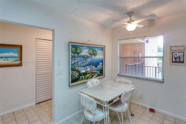 dining space with a textured ceiling and ceiling fan