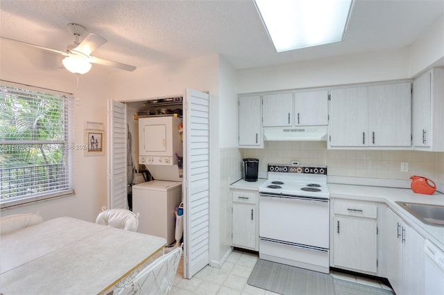 kitchen with stacked washer and clothes dryer, sink, tasteful backsplash, ceiling fan, and white appliances